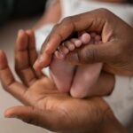 Pieds d'un bébé nouveau-né entre les mains de sa mère